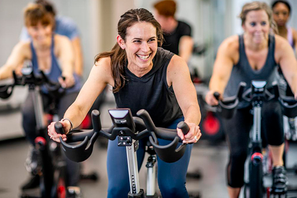 woman stationary bike spin class | cycling form