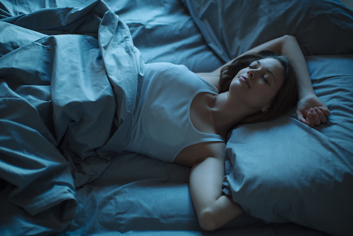 woman sleeping bed dark | healthy new years resolutions