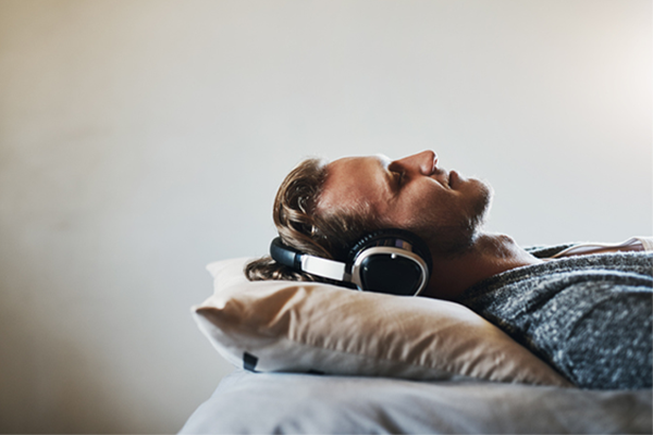 man sleeping with headphones on | how to fall asleep faster