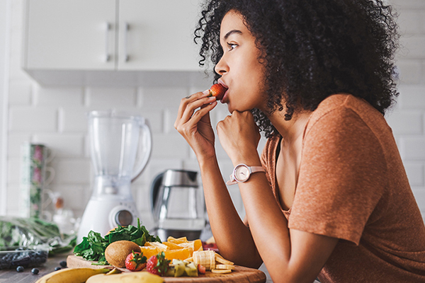 woman savoring strawberry food | health esteem