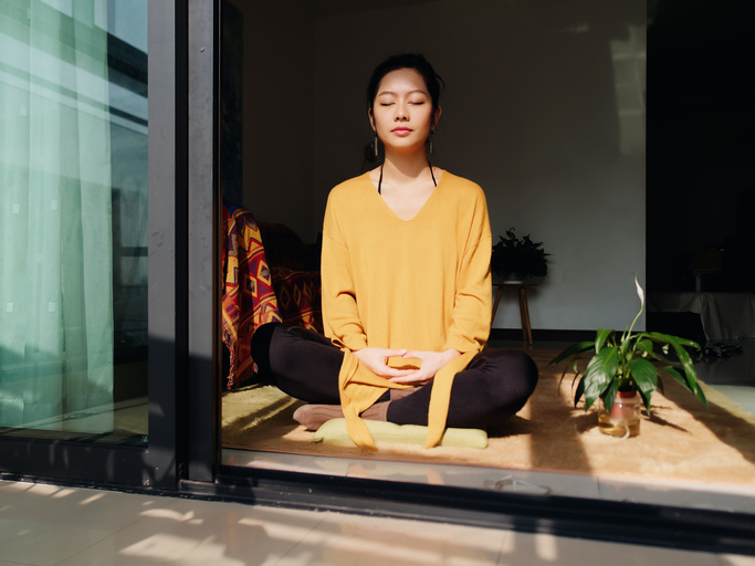 woman meditating in sunlight | meditation pillow