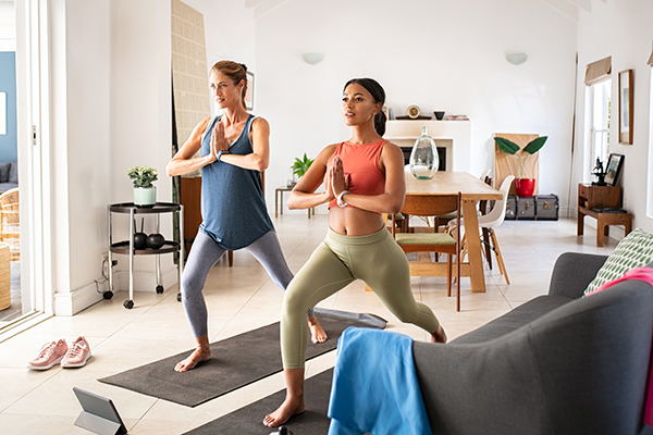 Two women doing yoga at home