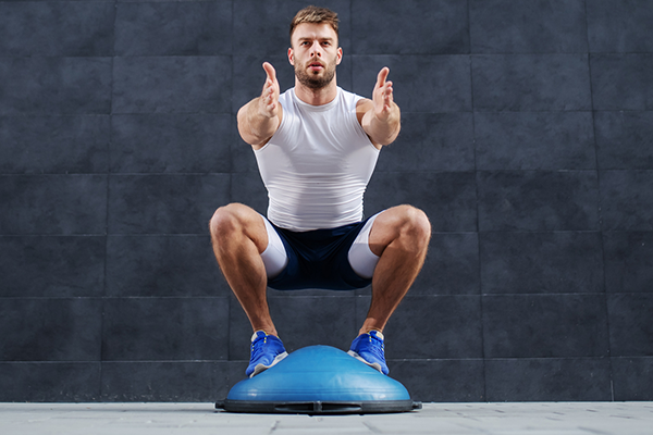 man squatting on bosu ball | proprioception exercises