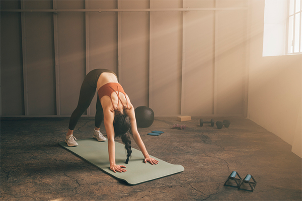 woman doing yoga in gym | Yoga Before or After Workout