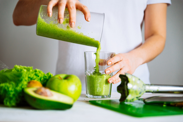 Pouring green smoothie into glass