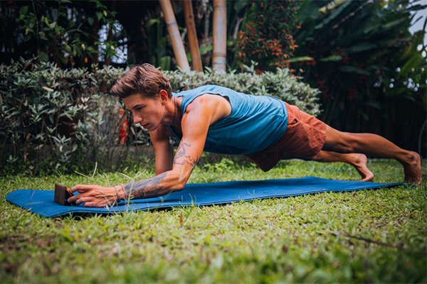 man doing yoga plank outside | Can You Work Out After Getting a Tattoo