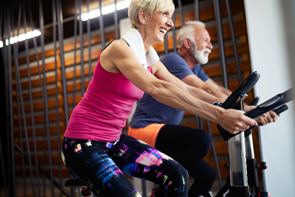 older couple indoor bike | health benefits of cycling