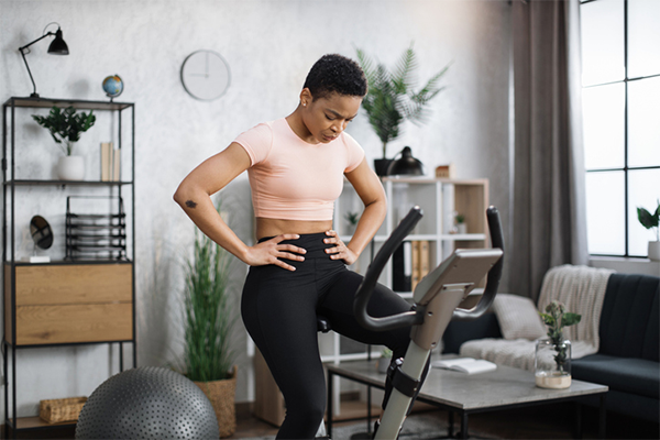 tired woman resting on stationary bike | Cycling Cadence