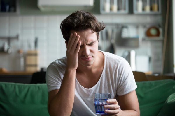 man holding head drinking water | congeners in alcohol