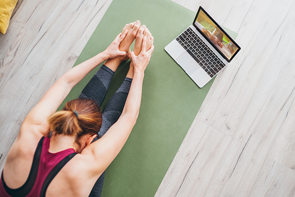 Woman Stretches in Front of Laptop | Does Stretching Burn Calories