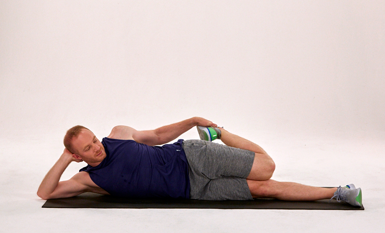 Man Lies on His Side While Stretching Quad | Quad Stretches