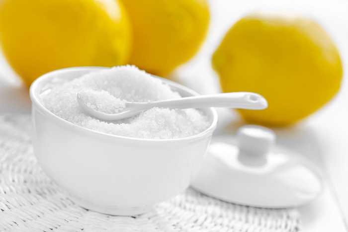 Bowl of Citric Acid in Front of Lemons | Cictric Acid