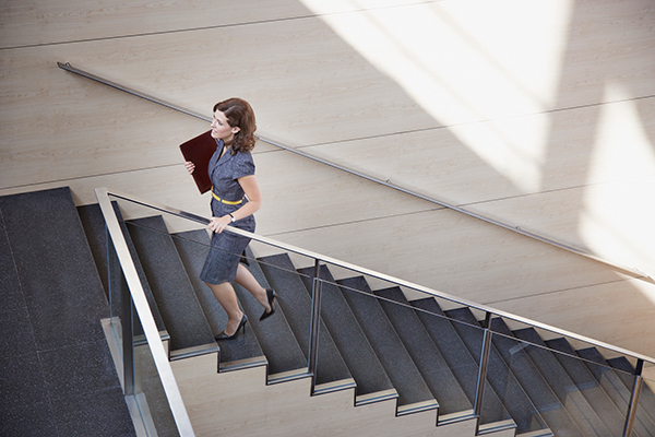 Femme en tenue de bureau monte les marches |  Combien de pas par jour