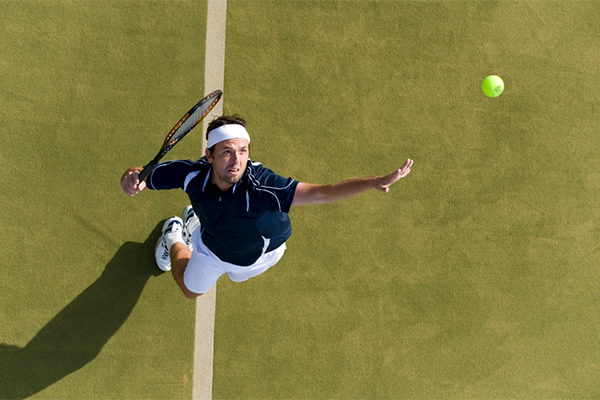 overhead view of man serving tennis | Grunting at the Gym