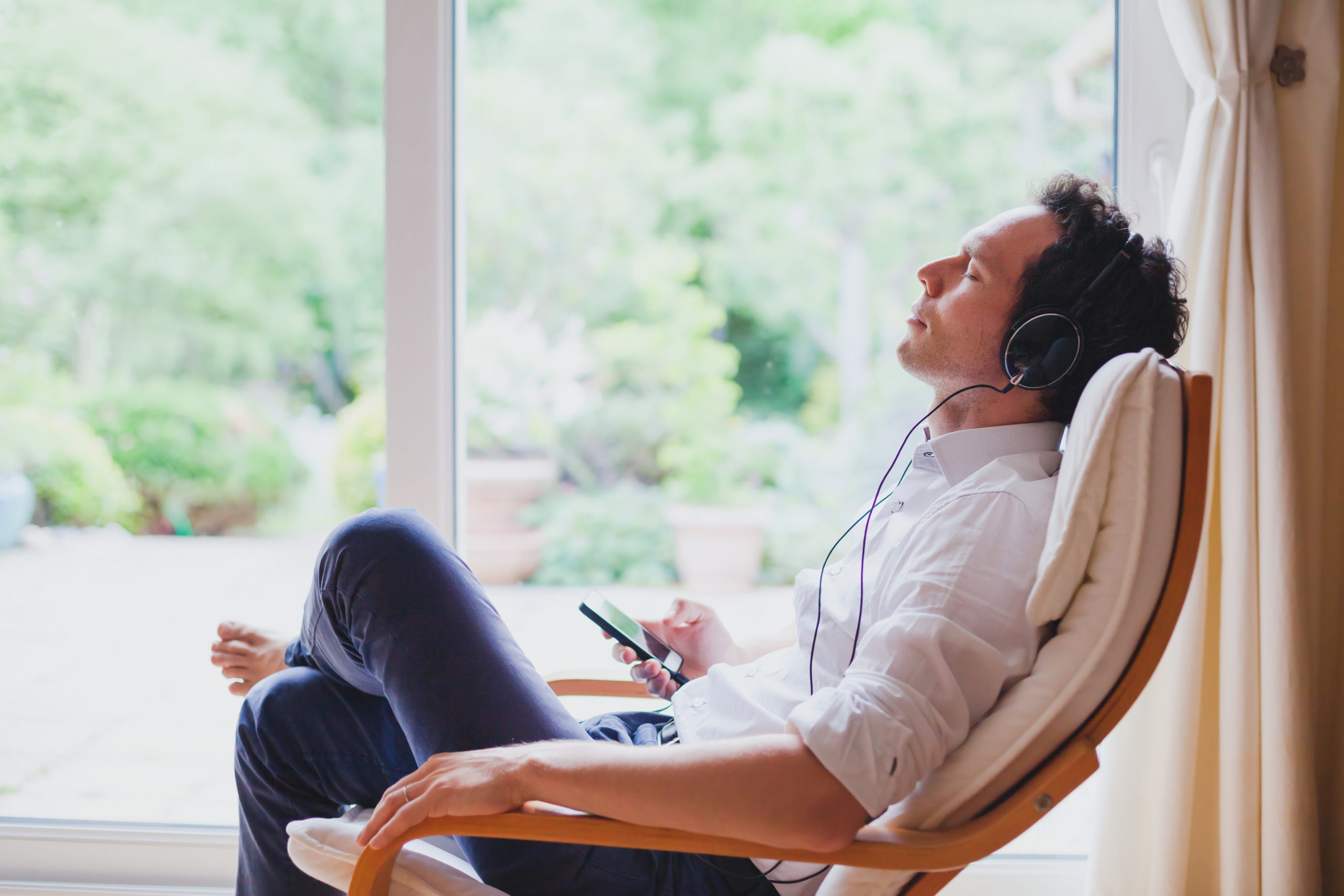 Man Meditates on Couch with Headphones | How Often Should You Meditate