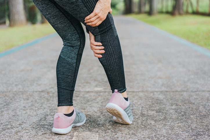 Woman holding a leg because of the pain of hamstring pnf stretching