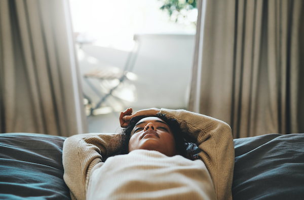 The woman lies on the bed and scan the body of the sleep meditation