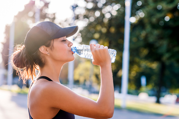 Frau trinkt Wasser beim Laufen | Flüssigkeitszufuhr-Ergänzungsmittel