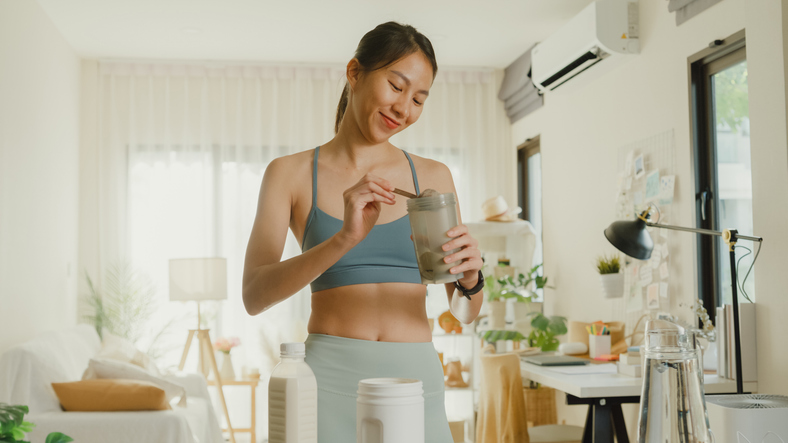 Woman Prepares post-workout protein shake | how to keep morning workouts from wearing you out