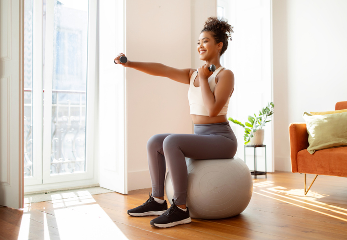 Femme s'entraîne à la maison sur un ballon de yoga |  comment éviter que les séances d'entraînement du matin ne vous épuisent