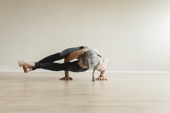 Woman Holds Eight Angle Pose | Power Yoga