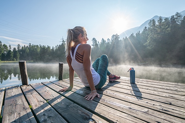 Woman Relaxes on Dock After Workout | Benefits of Quitting Drinking