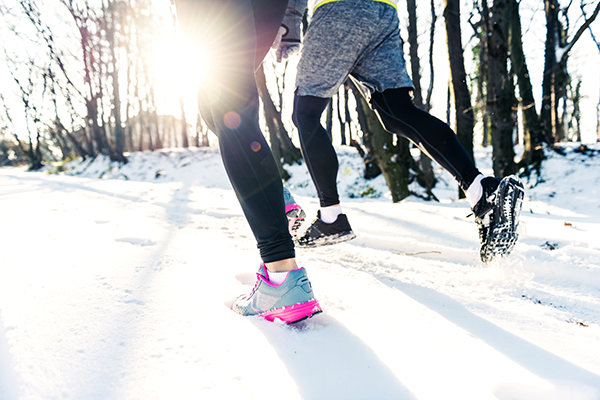 people running on snowy road | How to Stay Fit in Winter