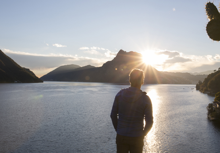 man looking out on lake sunshine | Vitamin D in Winter