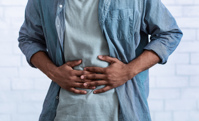 Man holding his stomach How much protein is too much?