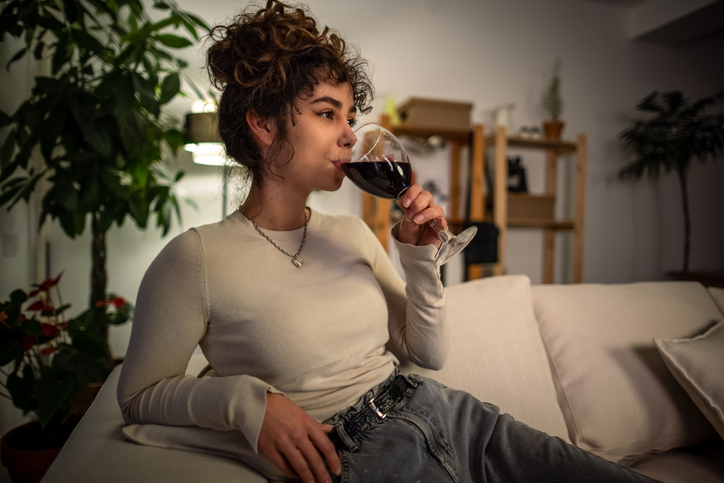 woman drinking wine on the couch | How to Reduce Night Sweats?