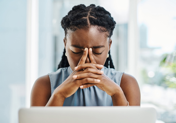 stressed woman at desk | Irregular Periods