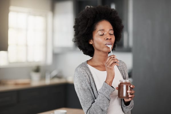 woman enjoying a bite of chocolate snack | Chocolate Facts