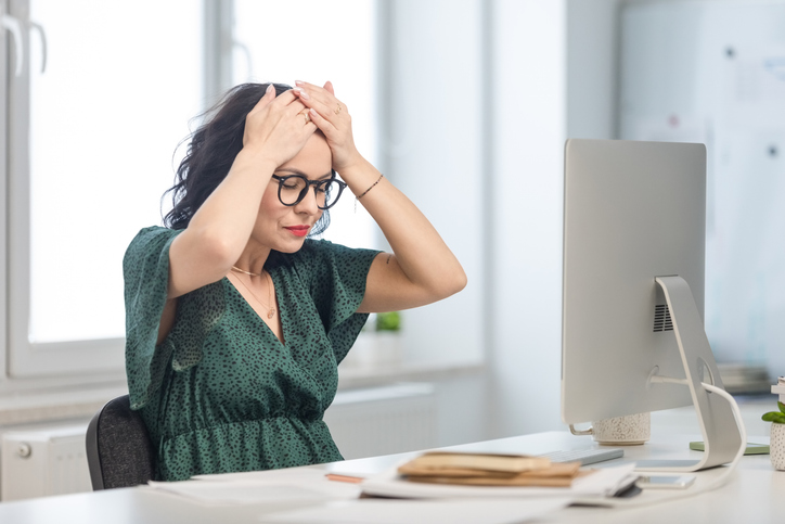 woman distressed at desk | Hot Flash Relief