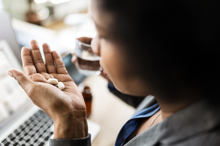 woman holding supplement pills