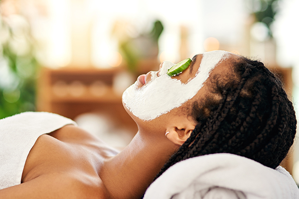 Woman with beauty mask, cucumbers on